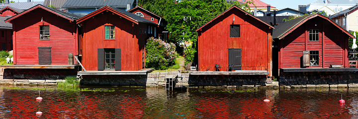 Red harbor warehouses with nice reflections on porvoo river. fishing village in scandinavian style. houses painted in swedish red