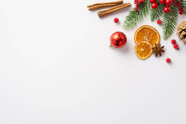 新年のコンセプト。白い背景に赤い安物の松ぼっくり乾燥オレンジスライスシナモンスティックアニスヤドリギの果実と霜のトウヒの枝、コピー用スペースのトップビュー写真 - pine tree pine cone branch isolated ストックフォトと画像