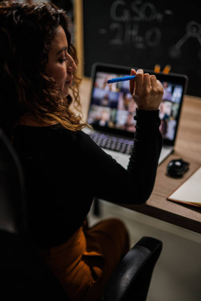 istock Businesswoman writing notes while attending a group video call with her coworkers 1441917486