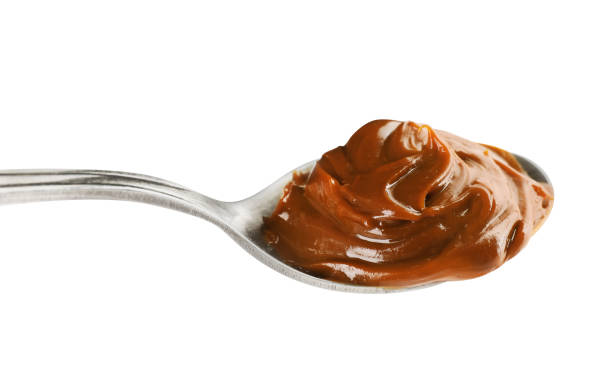 istock Spoon with tasty boiled condensed milk isolated on white 1441918140