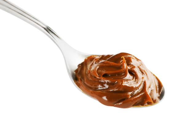 istock Spoon with tasty boiled condensed milk isolated on white 1441918478