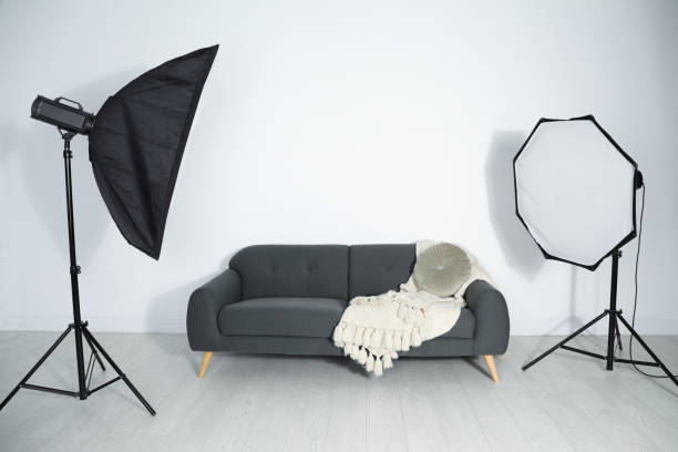 istock Comfortable sofa and professional lighting equipment in photo studio 1441918886