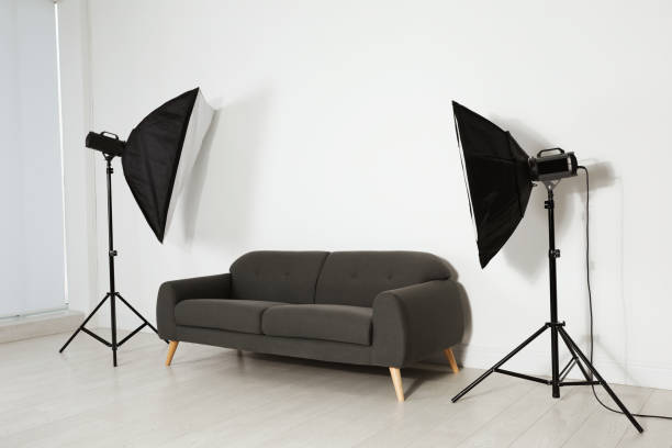 istock Comfortable sofa and professional lighting equipment in photo studio 1441918986