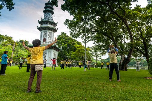 Bangkok, Thailand - July 2, 2012: people practicing Tai Chi in Lumphini Park early in the morning. Tai Chi is a Chinese martial art characterized by slow movements.