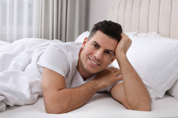 istock Happy man lying in bed at home 1441920242