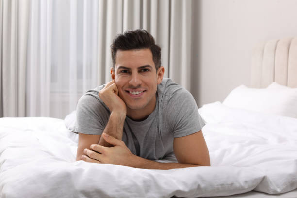istock Happy man lying on bed at home 1441920794