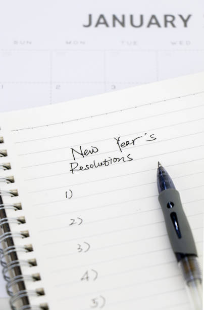 istock Preparing for the new year concept, list of new years resolutions on notepad with pen, in the background is January calendar 1441922018