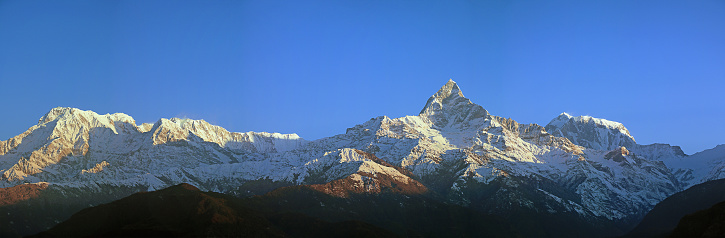 Sarangkot, Pokhara, Nepal - February 10, 2019: the photo was taken in Sarangkot (Pokhara) and shows a glimpse of the Himalaya mountain range, in particular a panoramic view of the Annapurna massif and the Machapuchare mountain (meaning fish tail in Nepalese) standing on the right and also nicknamed the “Matterhorn of Nepal”.