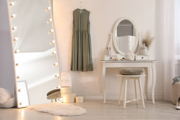 istock Large mirror with light bulbs and dressing table in stylish room. Interior design 1441922569