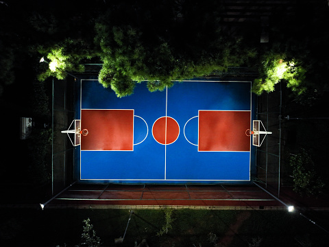 aerial view of illuminated basketball court in the middle of the night city, cityscape in nightlife, empty basketball court at night basketball court at night, night sport , background for sport