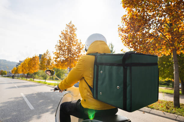 istock Unrecognizable delivery person driving scooter while delivering orders in the city 1441928748