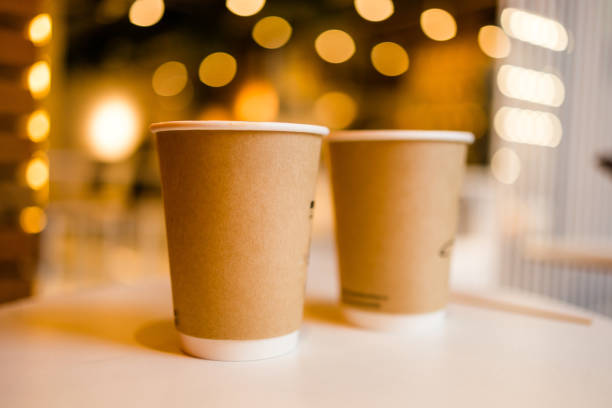 istock Close up two cardboard coffee cups take away on table over bokeh background copy space and empty space for text - coffee shop and take away drink concept 1441928925