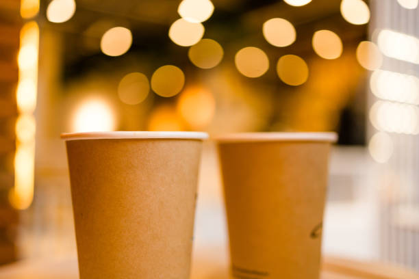 istock Close up two cardboard coffee cups take away on table over bokeh background copy space and empty space for text - coffee shop and take away drink concept 1441928941