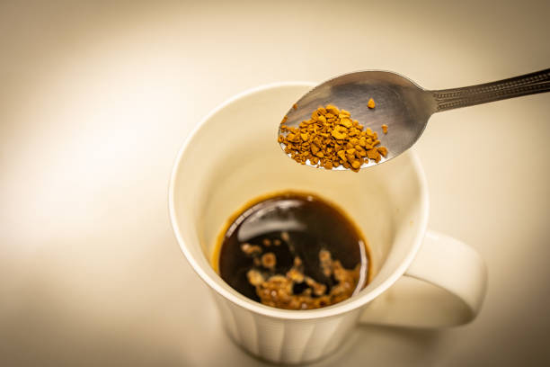 istock Hand holding a spoon to scoop coffee into a glass 1441929515