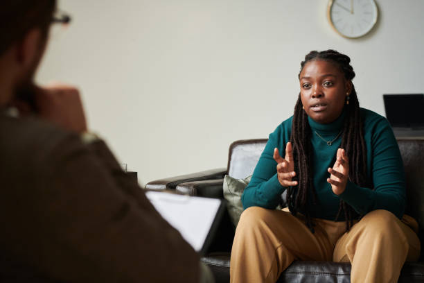 афроамериканская девушка разговаривает с психологом в офисе - furniture high angle view armchair above стоковые фото и изображения