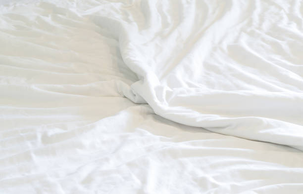 istock White wrinkled bedding sheet taken in hotel room with copy space, Blanket background texture 1441933132