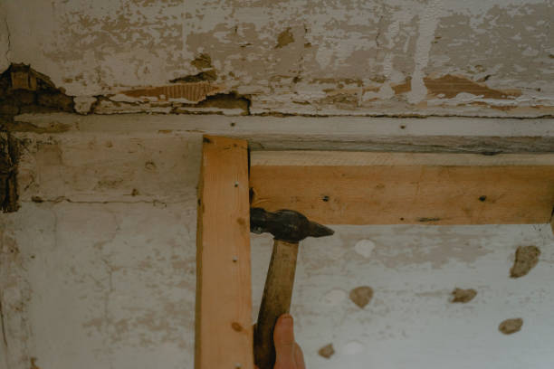 istock knocks with a hammer on a wooden frame, house reconstruction 1441933693