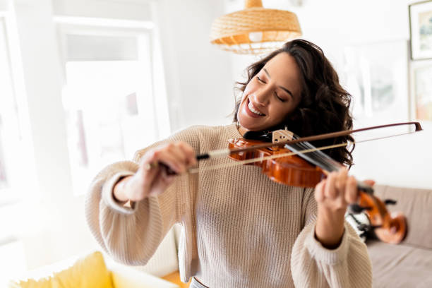 istock Young woman plays a violin at home smiling 1441933984