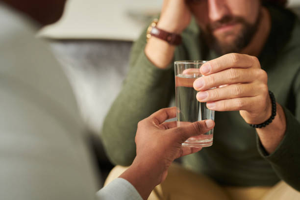 istock Depressed patient drinking water during consultation 1441934717