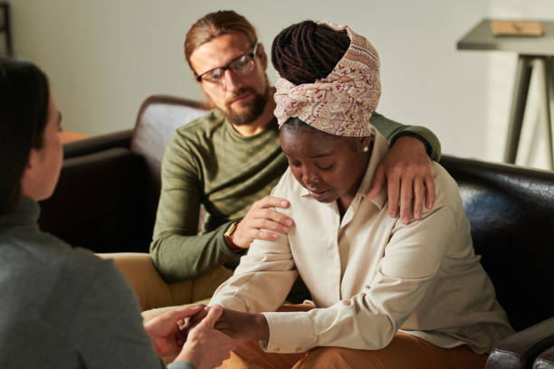 istock Depressed couple talking to psychologist at office 1441935249