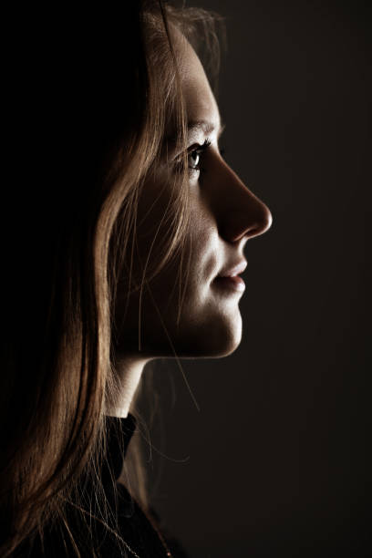 istock Low light side view of woman studio portrait 1441936780