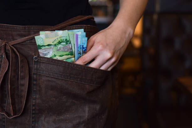캐나다 지폐 현금을 들고 있는 웨이트리스 손에 근접 촬영 - minimum wage 뉴스 사진 이미지