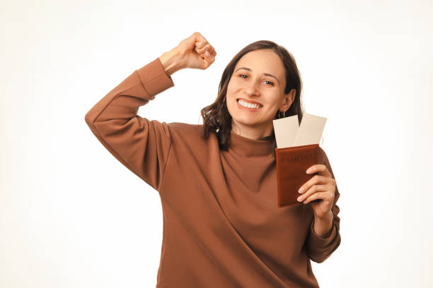 istock Victorious woman is gesturing with passport in hands because she won a trip. 1441940971