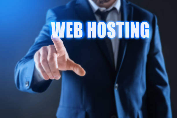 istock Businessman pointing at phrase WEB HOSTING on virtual screen against dark background, focus on hand 1441942232