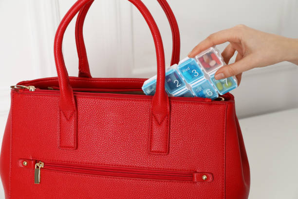 istock Woman putting pill box into bag indoors, closeup 1441945109