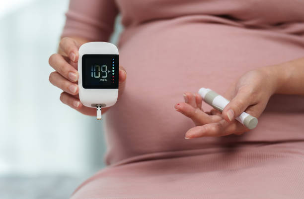 wanita hamil memegang pengukur glukosa dan memeriksa kadar gula darah sendiri di rumah. konsep diabetes gestasional. - diabetes gestasional potret stok, foto, & gambar bebas royalti