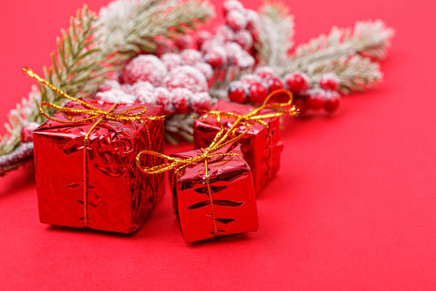 istock Christmas tree branch with toys and a gift on a red background 1441947066