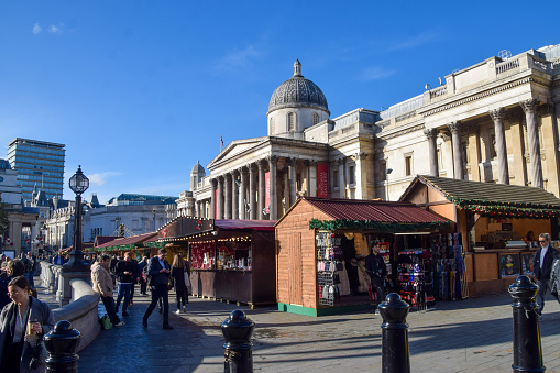 London, UK - November 16 2022.  People visit the Christmas market stalls outside the National Gallery at Trafalgar Square.