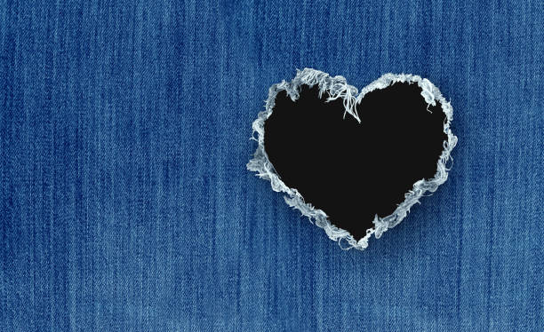 Fashion Love Fashion love and clothing apparel retail industry as clothes trends and garments wearing denim orblue jeans pants as textile with a hole shaped as a heart as a symbol for Valentine or romance hole in pants stock pictures, royalty-free photos & images