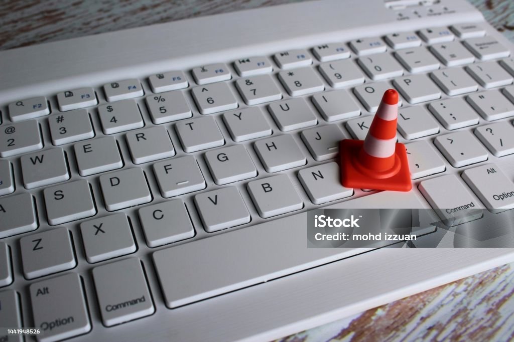 Safety cone and keyboard computer Computer system under construction, maintenance, repair concept. Safety cone and keyboard computer Construction Site Stock Photo