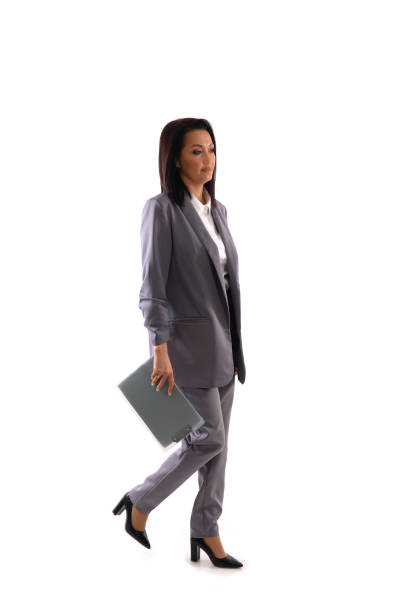 Full length portrait of confident senior businesswoman standing arms crossed. Vertical shot. Isolated on white.