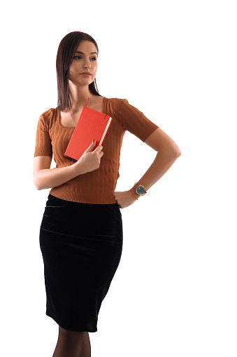 Beautiful woman holds her copybook standing in front of white background