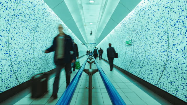 Time lapse of Crowded Commuter people in tunnel walkway between underground interchange station in London