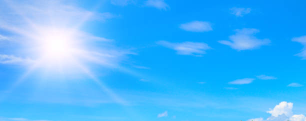 istock blue summer sky with fluffy clouds and bright sun as a background. Wide photo. 1441950880