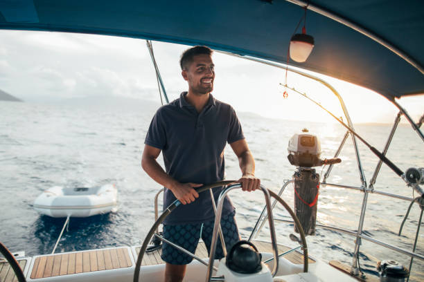 junger mann genießt das segeln - sailboat sailing yacht nautical vessel stock-fotos und bilder