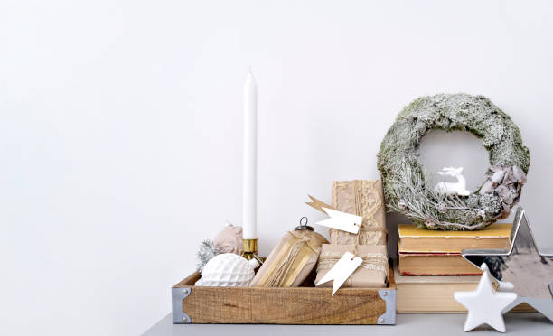 istock Winter holiday composition with copy space. Frosted spruce wreath, gift boxes, shiny baubles and candle in wooden tray. Get into the festive season with a Christmas beautiful decoration. 1441953620