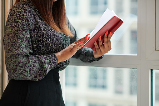 Cropped image of female entrepreneur reading her planner before starting new day