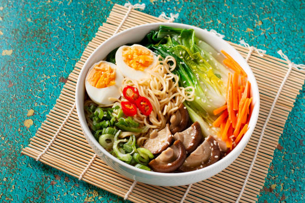 istock Ramen noodle soup with eggs, mushrooms, pak choi in white bowl 1441963902