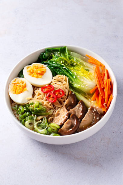istock Ramen noodle soup with eggs, mushrooms, pak choi in white bowl 1441963903