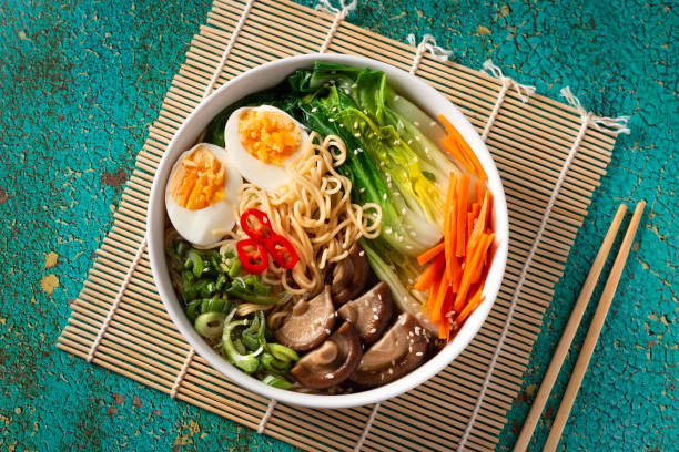 istock Ramen noodle soup with eggs, mushrooms, pak choi in white bowl 1441963909