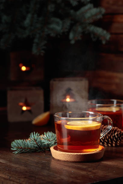 istock Tea with lemon and small Christmas lanterns on a wooden table. 1441967298