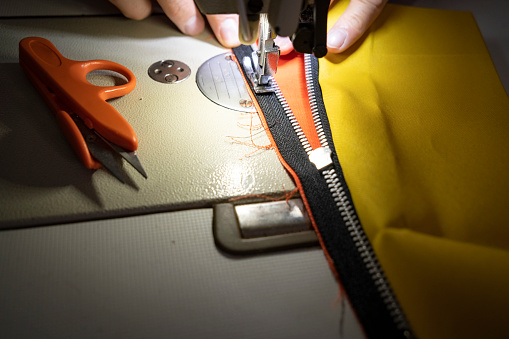 Man tailor at work on sewing machine.