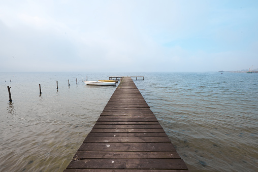 Wooden jetty or pier on lake in a foggy mood.