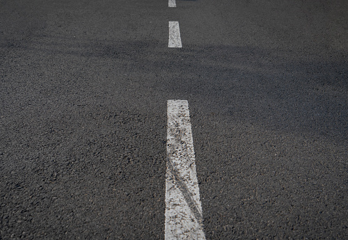 White lines dividing a freshly laid road.