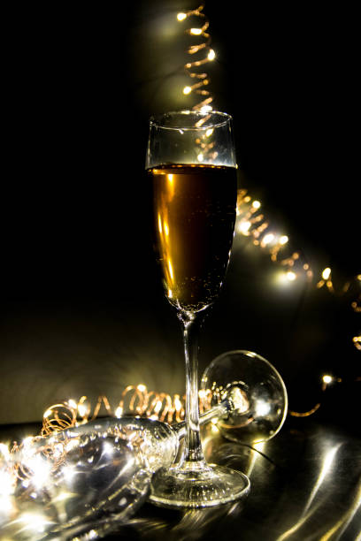 bicchiere di champagne con luci natalizie. copia spaziale. - wine christmas alcohol evening ball foto e immagini stock