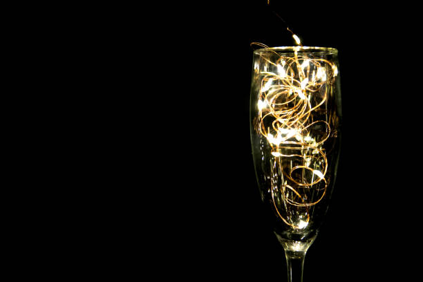 bicchiere di champagne con luci natalizie. copia spaziale. - wine christmas alcohol evening ball foto e immagini stock